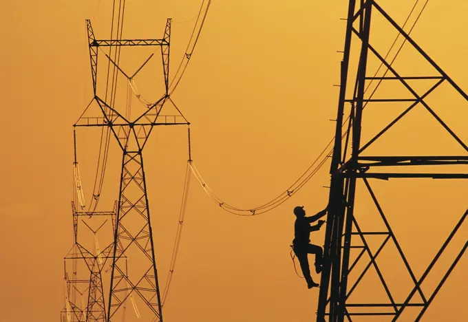 A worker climbs an electrical tower, Manitoba, Canada