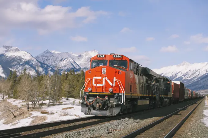 A CN Canadian National locomotive engine and train on the CN railway tracks near Jasper, Alberta, Canada in the Canadian Rocky Mountains