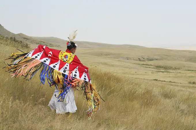 Blackfoot Piikani woman Fancy Shawl dancing on the Canadian prairies at Head Smashed In Buffalo Jump