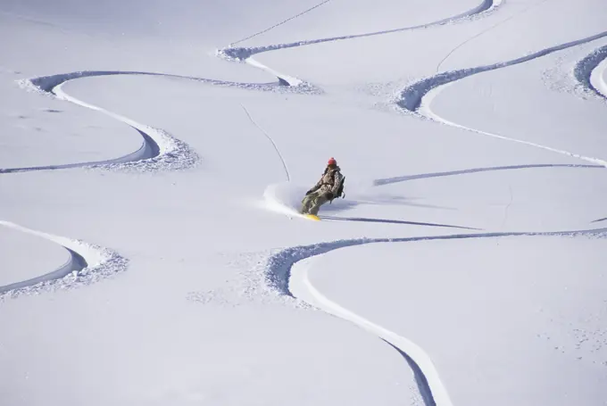 young female backcountry snowboarding in Golden, British Columbia, Canada.