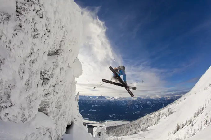 A male skier catches some air off a cliff in the Revelstoke Mountain Resort, Revelstoke Backcountry, BC