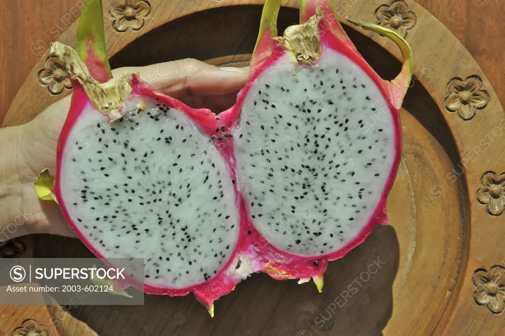 Close-up of two halves of pitaya in a person's hand, Thailand