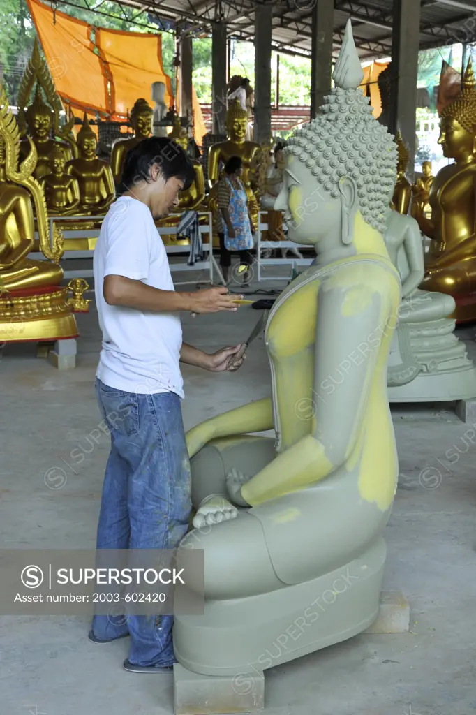 Thailand, Chonburi Prov, Ban Saen, Man painting statue in Ang Sila foundry