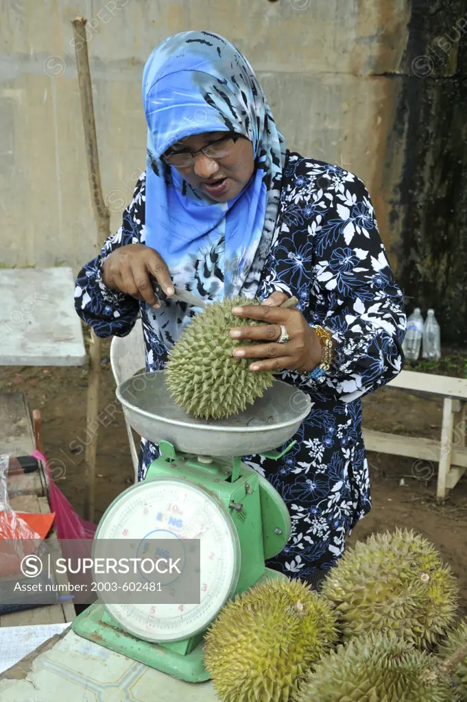 Female street vendor selling Durian (Durio zibethinus) and Mangosteen (Garcinia mangostana)