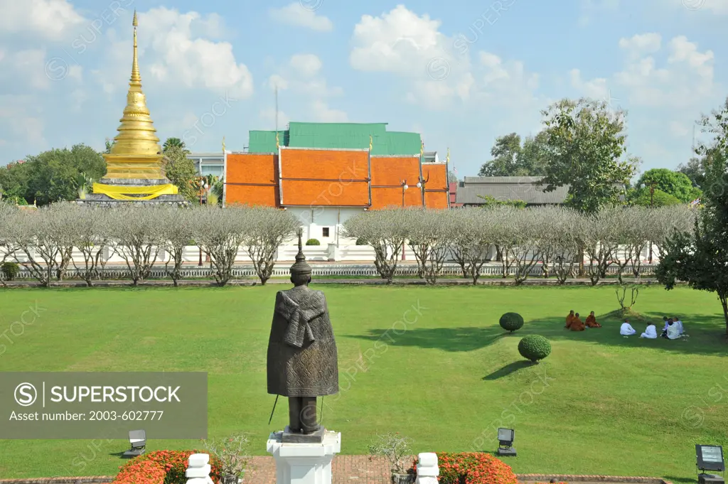 Thailand, Nan, Wat Chang Kham as seen from Nan National Museum. Statue is Feudal Lord of Nan Phrachao Suriyaphong Pharitdeg