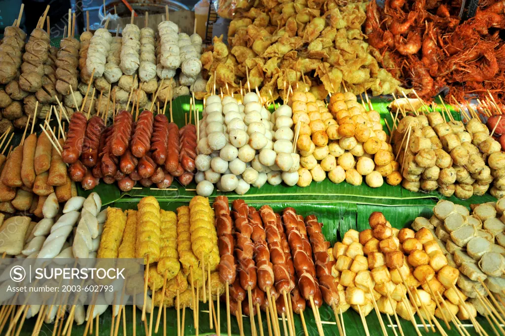 Thailand, Khon kaen, Thai Pork satays, sausage snacks with sweet sauce and seafood such as shrimp and squid at vendors stall