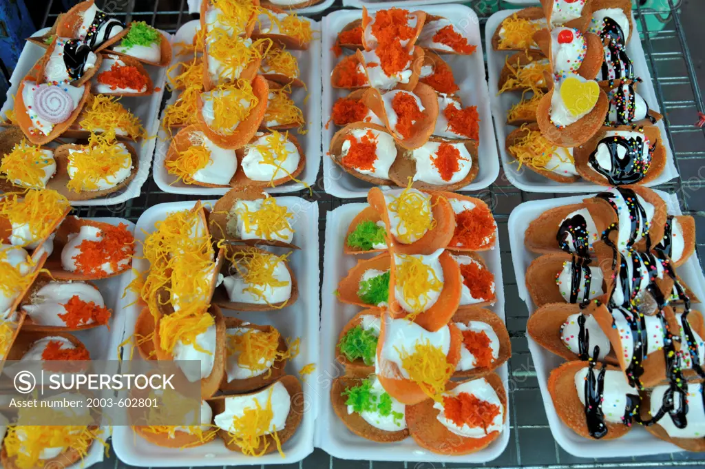 Thailand, Khon kaen, Crispy Thai pancakes, Khanom Buang with coconut cream filling and various toppings such as shredded coconut, eggs yolk, spring onions, chocolate and sugar sprinkles