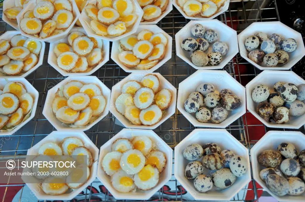 Thailand, Khon kaen, Quail Eggs, popular Thai snack, raw at right and cooked at left, at food stall of Silk Festival