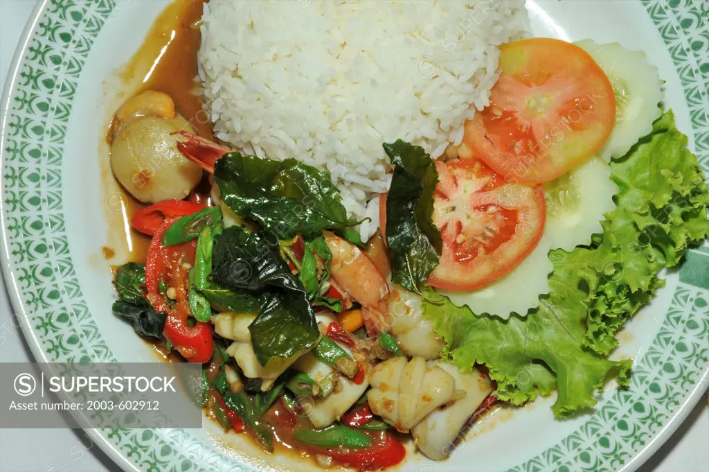 Thai fried rice served with basil leaves and salad