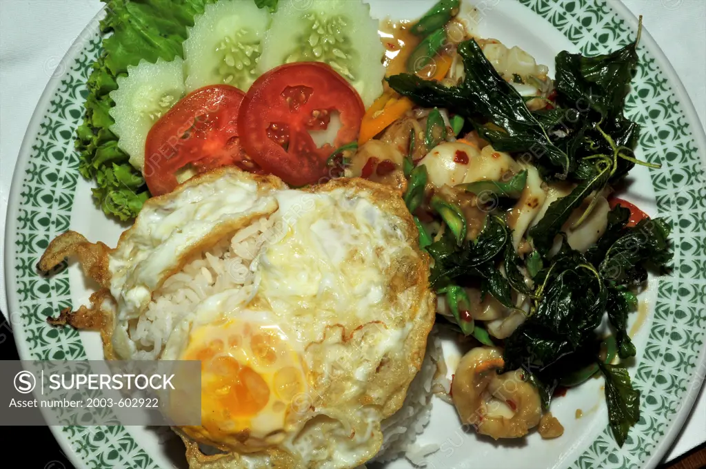 Thai fried rice served with basil leaves and salad
