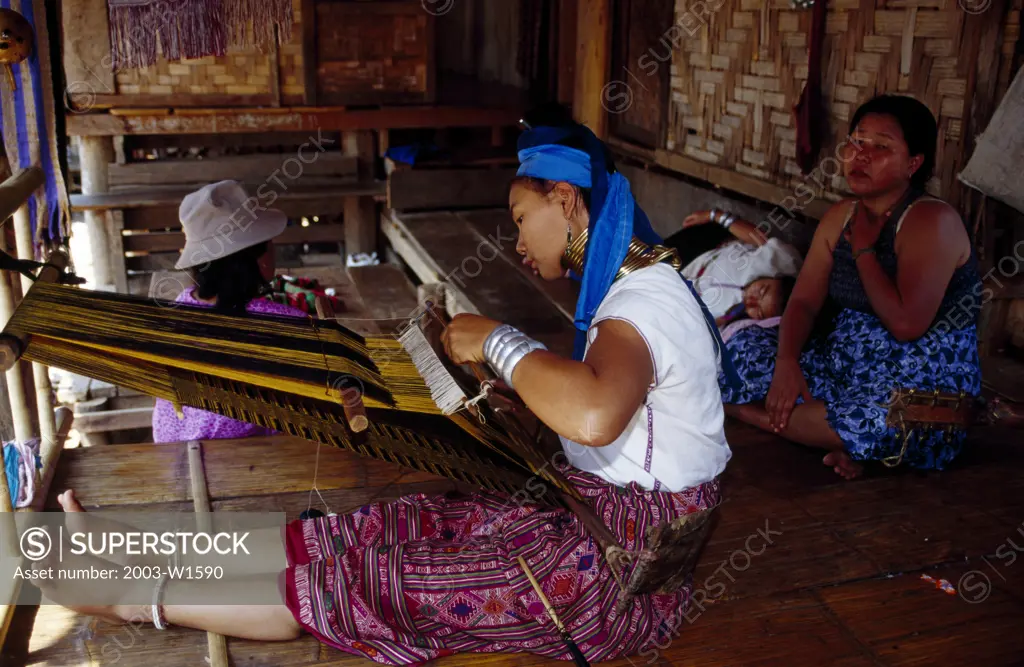 Side profile of a Karen woman working on a loom, Ban Huay Pu Keng, Thailand