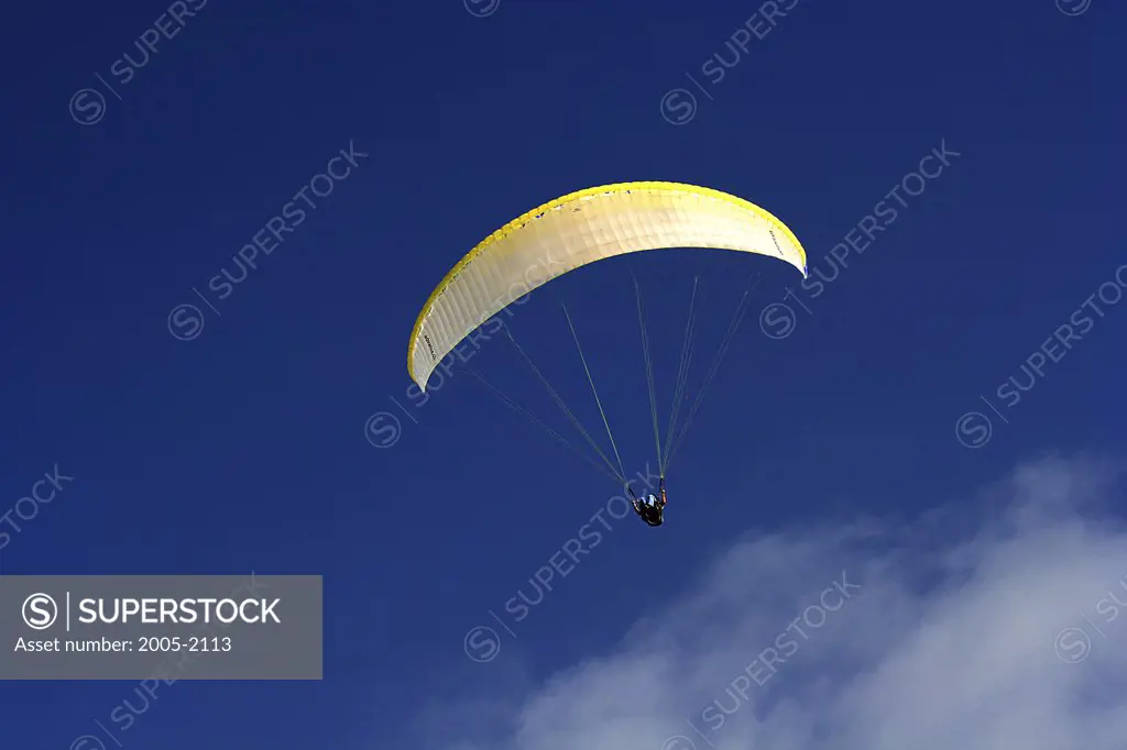 Low angle view of a person paragliding in the sky