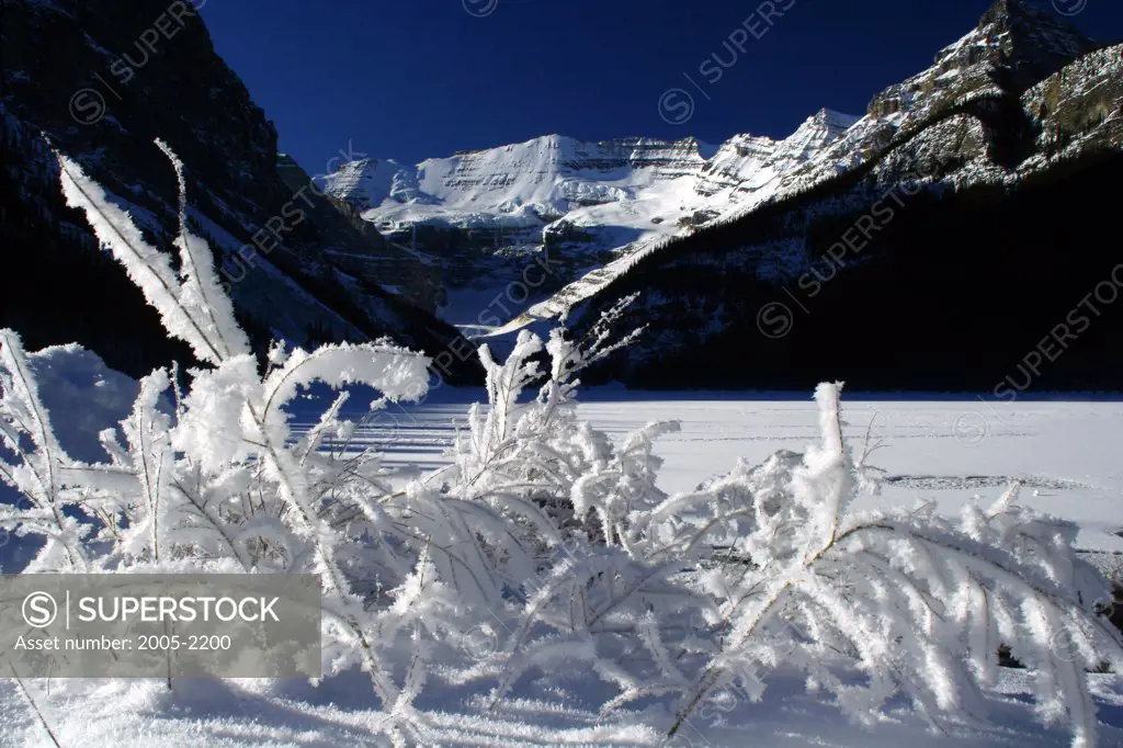 Frozen lake in front of mountains, Lake Louise, Victoria Peak, Banff National Park, Alberta, Canada