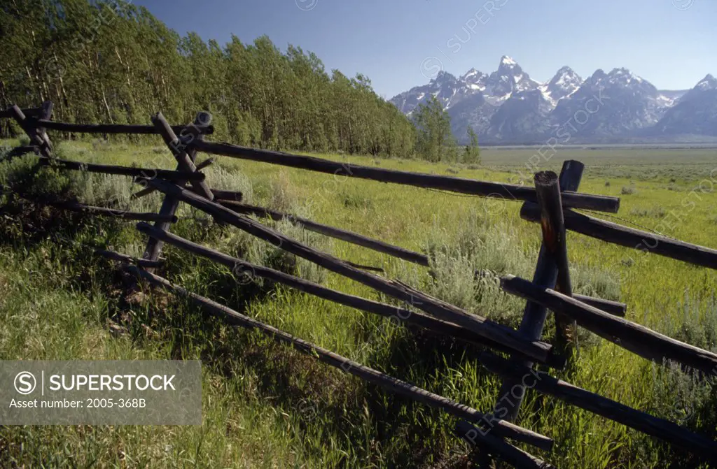 Fence in a field with mountains in the background, Teton Range, Grand Teton National Park, Wyoming, USA