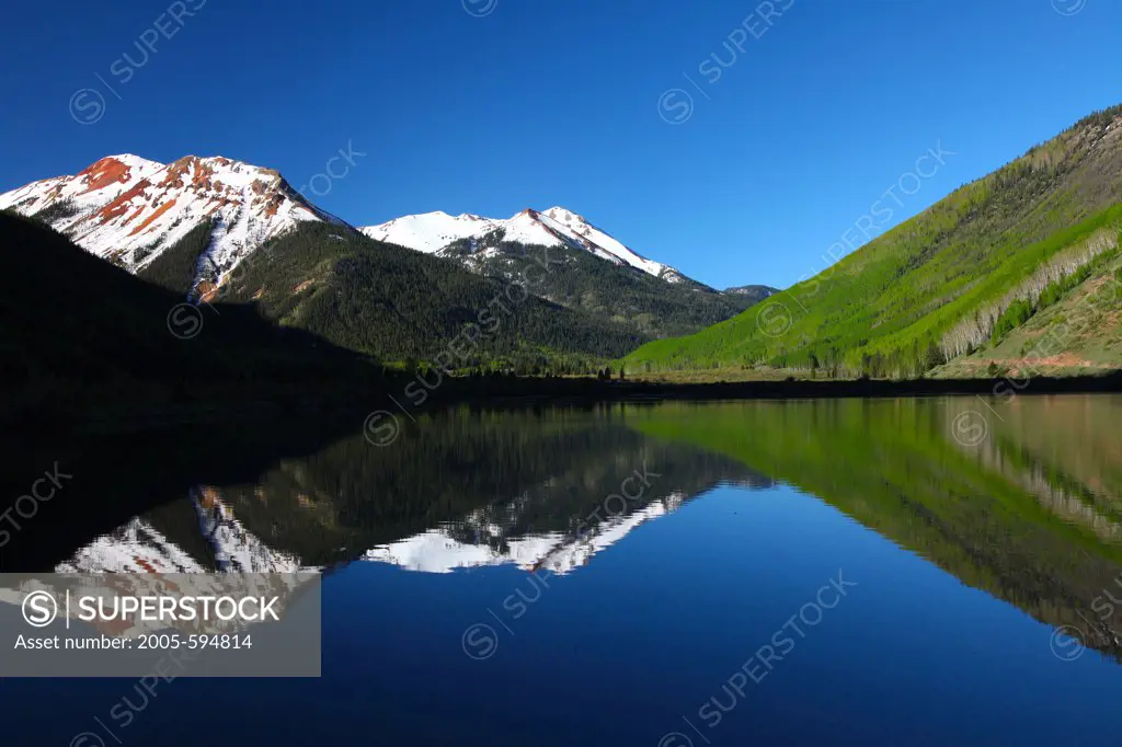 USA, Colorado, Uncomphagre National Forest, Red Mountain reflecting in lake