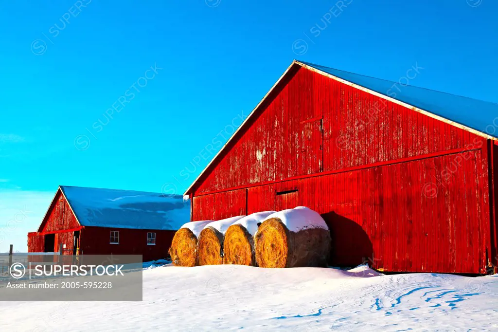 USA, Minnesota, Red Barn and Hay Bales in Winter