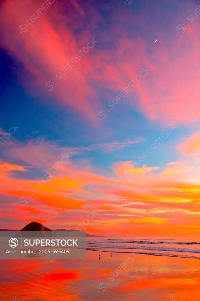 USA, California, Morro Strand State Beach, Moonrise over Morro Rock and sunset on beach