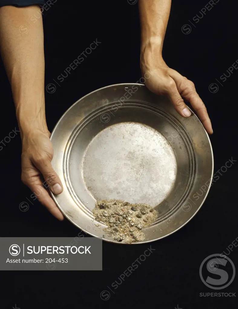 High angle view of a person's hands panning for gold