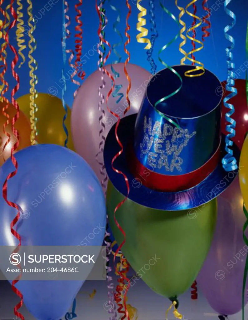 Close-up of a party hat with balloons and streamers