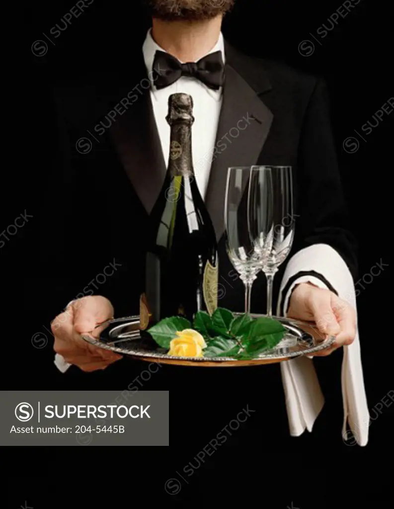 One man holding a tray with a bottle of Champagne and two glasses