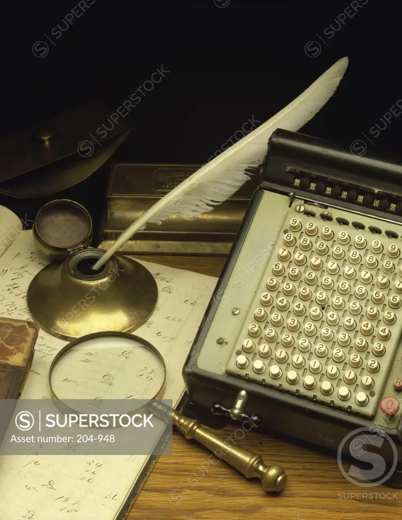 High angle view of an antique calculator and quill pen