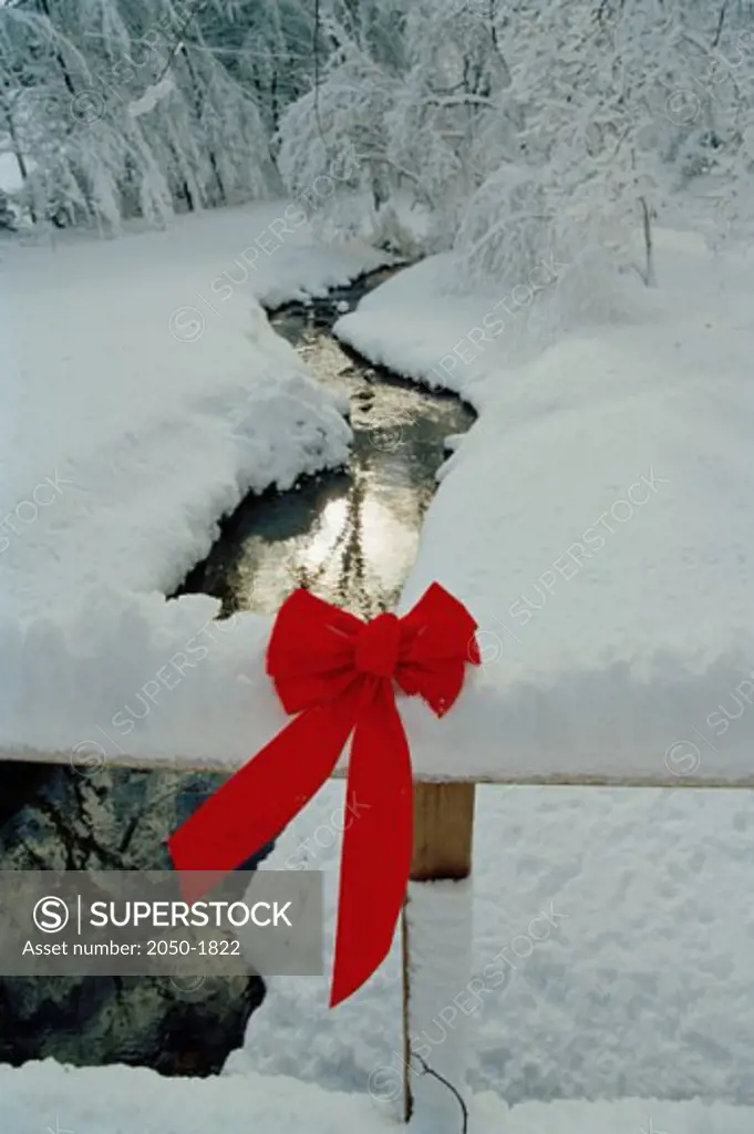 Christmas decorations on an wooden fence outside in the snow 