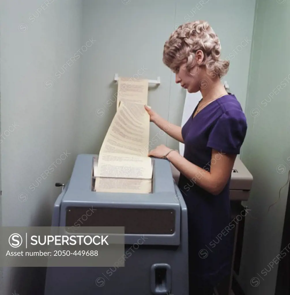 Side profile of a young woman using a teletype machine