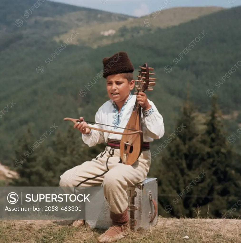 Boy playing a stringed musical instrument, Gadulka Musician, Bulgaria