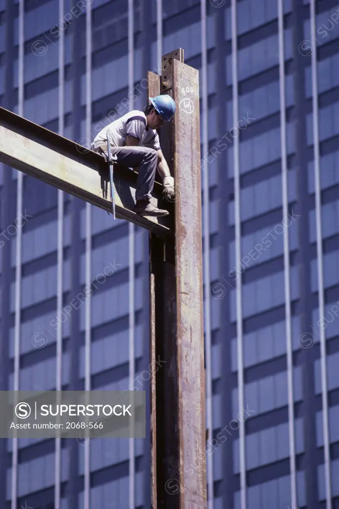 Low angle view of a construction worker working on a metal beam
