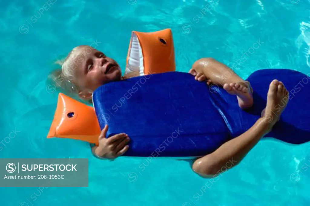High angle view of a boy floating on water with a pool raft