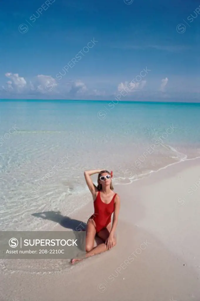 High angle view of a young woman posing on the beach