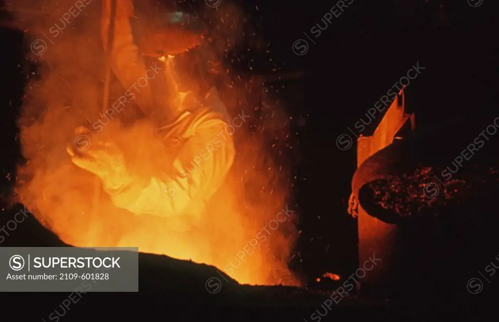Foundry worker stirring a titanium alloy mix