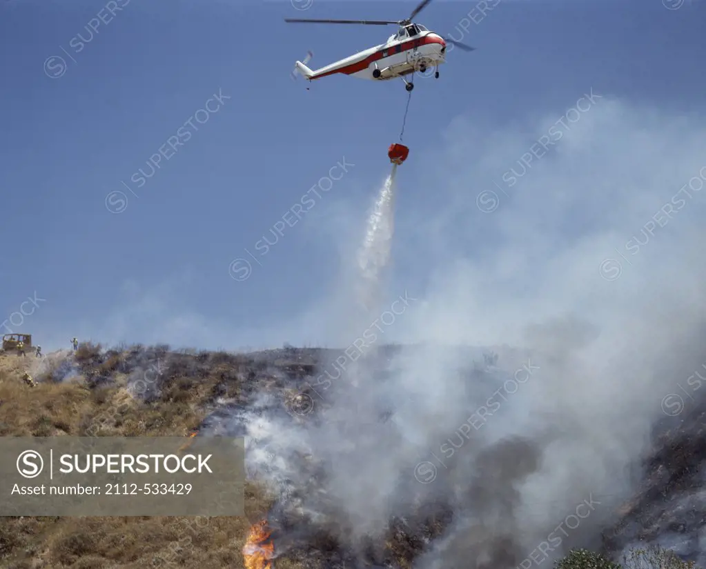 Helicopter Making Water Drops Over Canyon Forest Fire