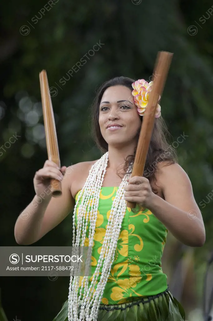 Hawaii, Kona, Traditional kahiko hula dancer with pu'ili (bamboo rattle sticks) at hula performance