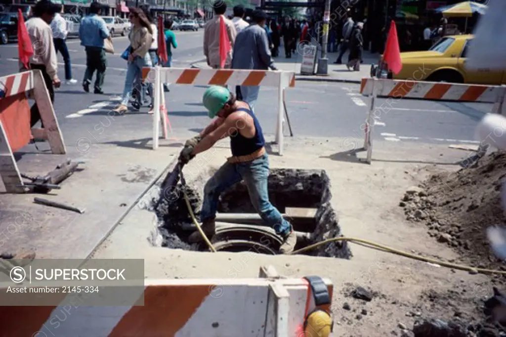 Road worker using a jackhammer, New York City, USA