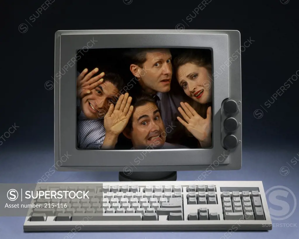 Portrait of three businessmen and a businesswoman in a computer monitor