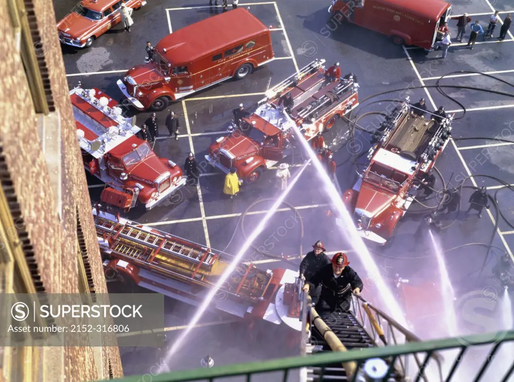 High angle view of firemen spraying water on a building