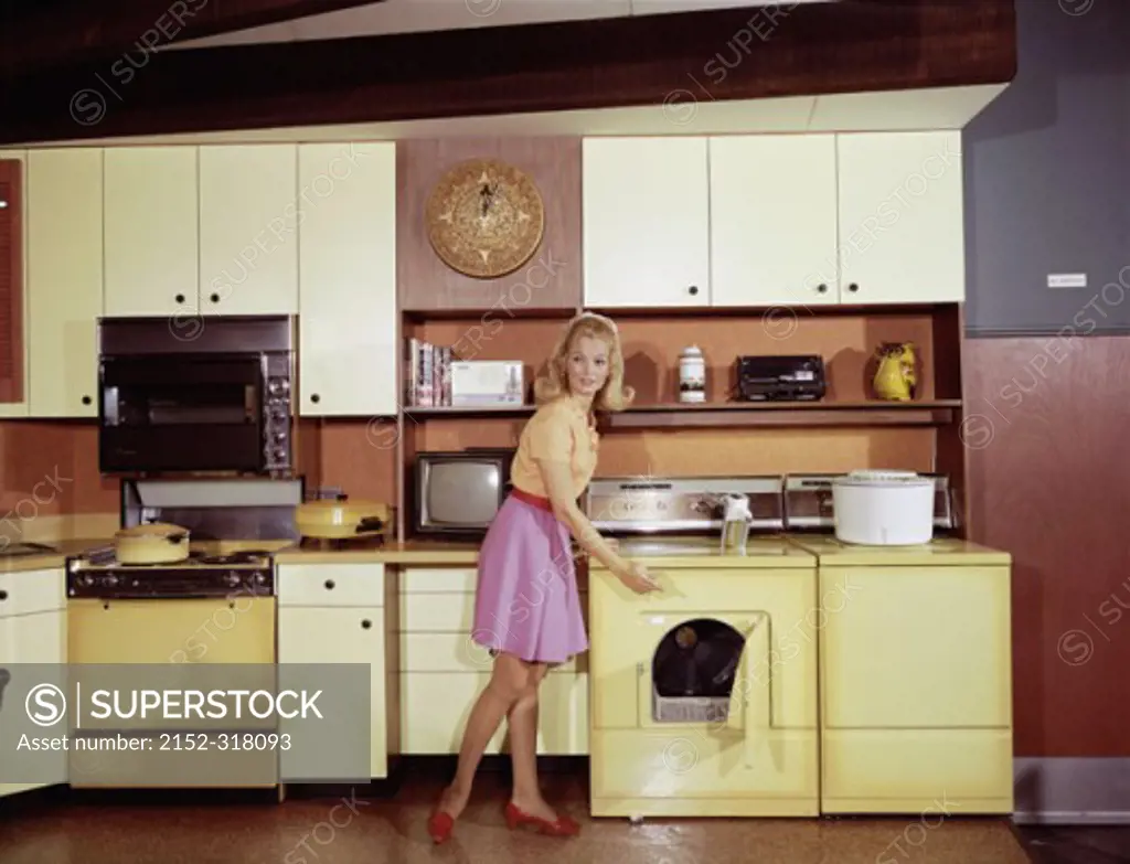 Side profile of a young woman standing in the kitchen