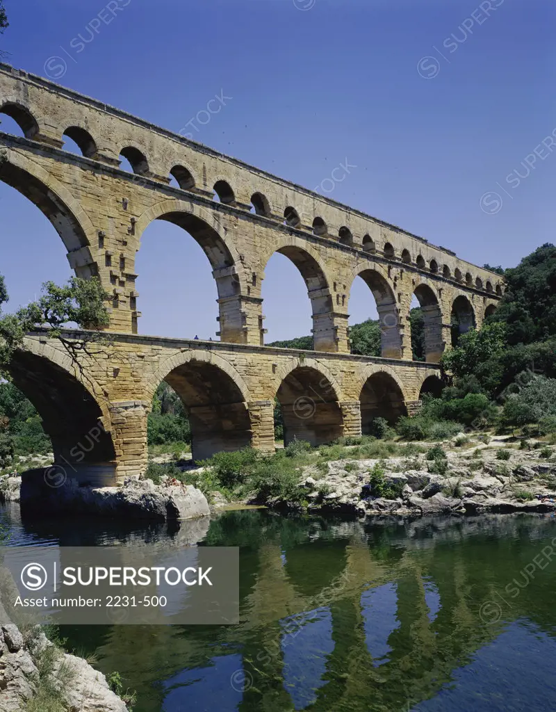 Reflection of an aqueduct in water, Pont du Gard, Nimes, France
