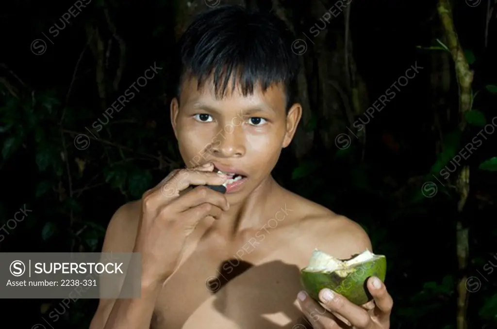 Portrait of a boy eating Habilla, Rio Yanayacu, Loreto Region, Peru