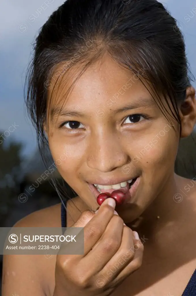 Girl eating Yumanasa fruit, Rio Puinahua, Loreto Region, Peru