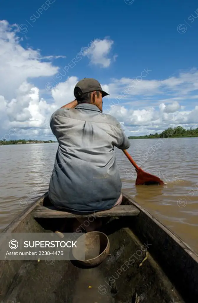 Rear view of a man paddling a boat, Tigre River, Loreto Region, Peru