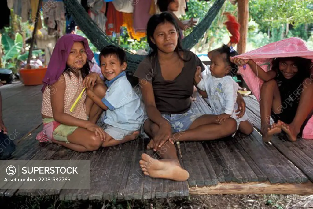 Family sitting on the floor, Nueva Esperanza, Pacaya-Samiria National Reserve, Loreto Region, Peru