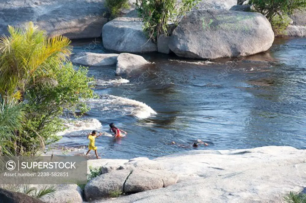 Rapids over granitic boulders on Precambrian shield. Children playing in the rapids. Pichacao, spray paintings on boulder. Sao Gabriel da Cachoeira, Rio Negro, Amazonas, Brazil, 10-24-12