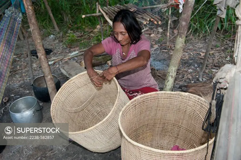 Yuhupde (Maku) woman weaving a basket (atura) with strips of a vine (Heteropsis) at a fish camp. She is making the basket to trade for goods. Lower Tiquie River, affluent of the Uaupes, Amazonas, Brazil, 10-26-12