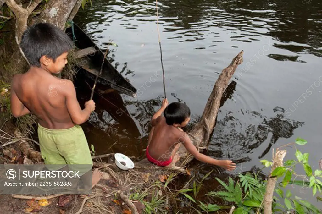 Tukano boys fishing with poles (canico). They are using worms as bait. Canoe is fashioned from yukusogu tree trunk and was made by Tuyuka. Cachoeira Caruru, Rio Tiquie, affluent of the Uaupes, Amazonas, Brazil, 10-31-12