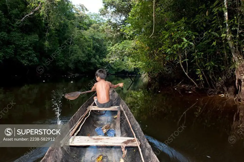 Makuna boy, Junildo 5 yrs, paddling a canoe to go fishing. Sao Pedro, Rio Tiquie, affluent of the Uaupes, Amazonas, Brazil, 11-7-12