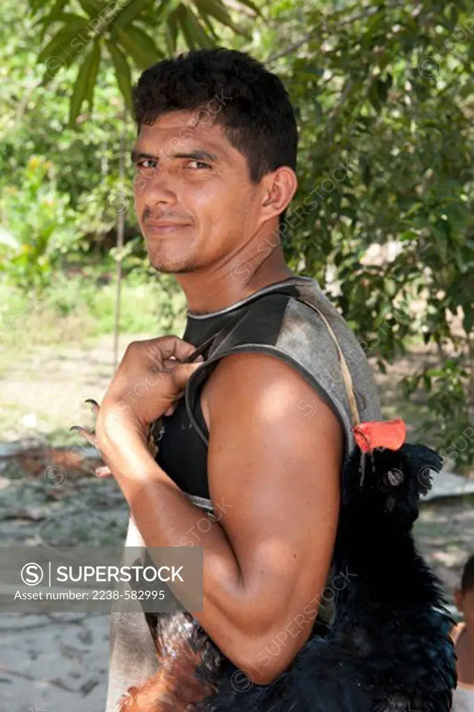Hunter, Louis 32 yrs, with a razor-billed curassow (Mitu tuberosum) he has shot in the forest with a 20-bore shotgun. The curassow is known locally as mutum. The meat is eaten and the tail feathers are tied together to make dusters. Cacautuba, Tefe River, Amazonas, Brazil, 9-10-12