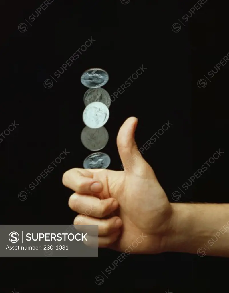 Close-up of a person's hand flipping a coin