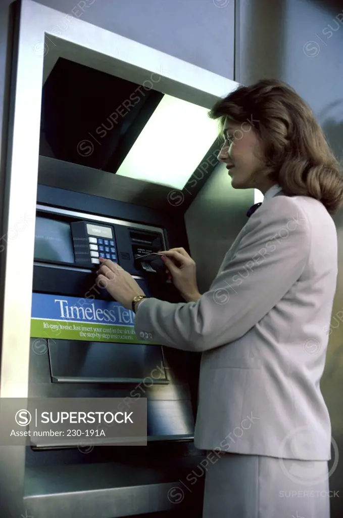 Businesswoman operating an ATM
